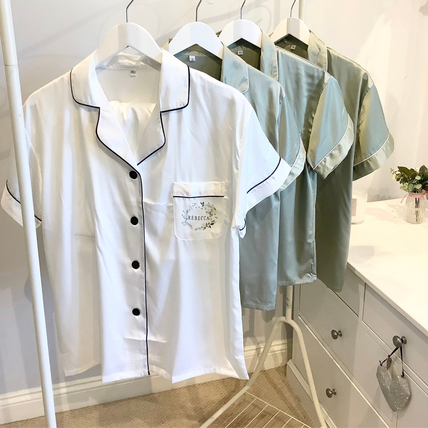 Set of pajama tops on hangers with a visible brand logo in a room setting.